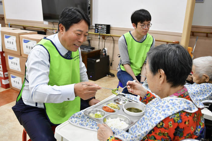 주재승 디지털금융부문 부행장(왼쪽)이 호계실버타운 어르신 점심식사를 돕고 있다.