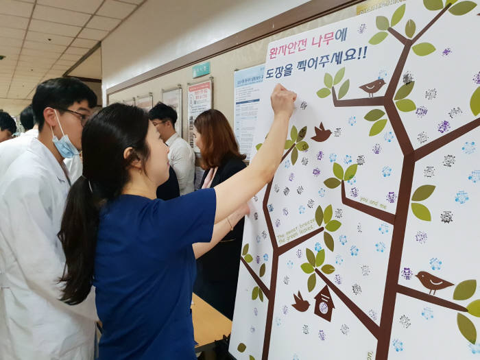 한림대성심병원 의료진이 환자안전 중요성을 담은 스탬프를 환자안전나무에 찍고 있다.