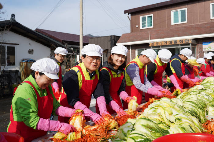 김광수 농협금융지주 회장(왼쪽 두 번째)과 임직원 봉사단, 자매마을 주민들이 농가에서 직접 재배한 배추, 무 등 우리농산물로 김장김치를 담그고 있다.