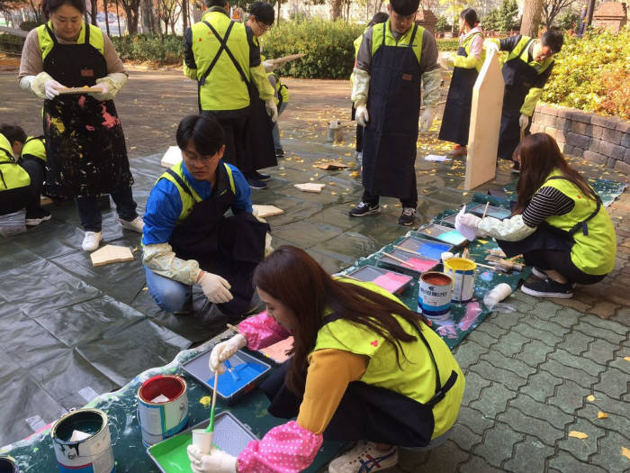 BNK부산은행 직원 자원봉사자들이 화명종합사회복지관에서 벽화그리기 봉사를 하고 있다.