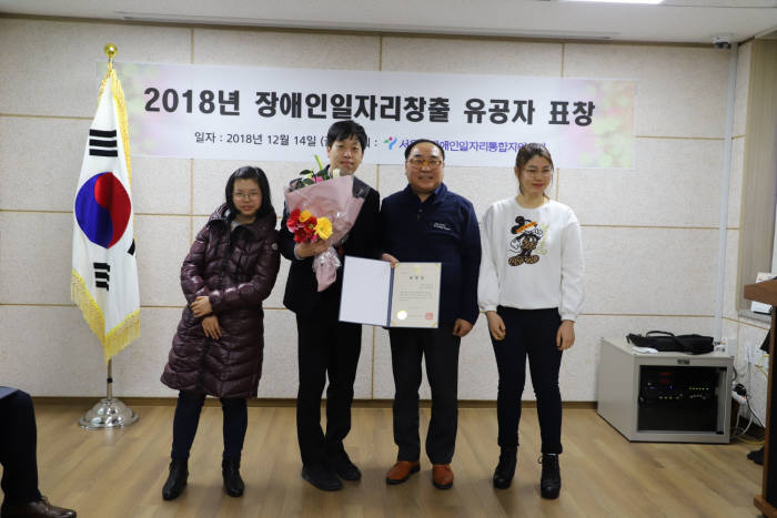 한태정 뉴딘파스텔 대표(사진 왼쪽에서 두번째)와 김영배 서울시장애인일자리통합지원센터 원장(왼쪽에서 세번째)이 장애인 직업합창단인 골프존파스텔합창단 단원들과 지난 14일 장애인일자리 창출 유공 서울시장 표창을 수상한 뒤 기념촬영하고 있다. 사진출처=뉴딘파스텔