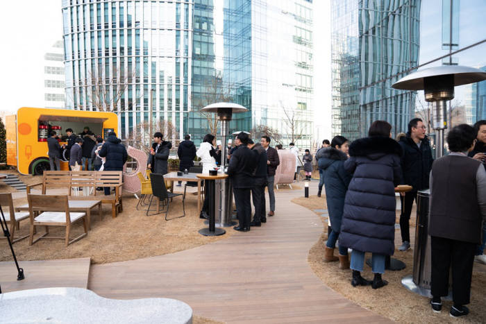 CJ ENM 임직원이 상암 사옥에 신설된 야외 녹지, 휴게공간에 마련된 시설을 이용하고 있다.