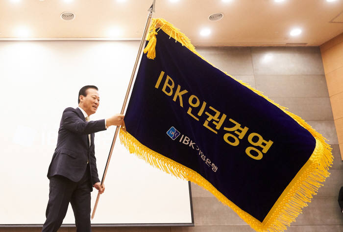 2일 서울 중구 을지로 기업은행 본점에서 열린 시무식 중 인권경영 선언식에서 김도진 행장이 IBK인권경영 브랜드기를 흔들고 있다.