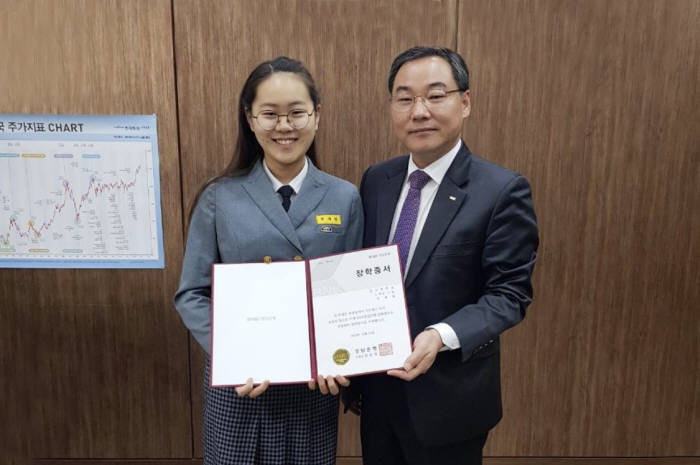 배재식 BNK경남은행 차룡지점장(오른쪽)이 9일 우수 거래 기업 자녀에게 장학증서를 전달하고 있다.