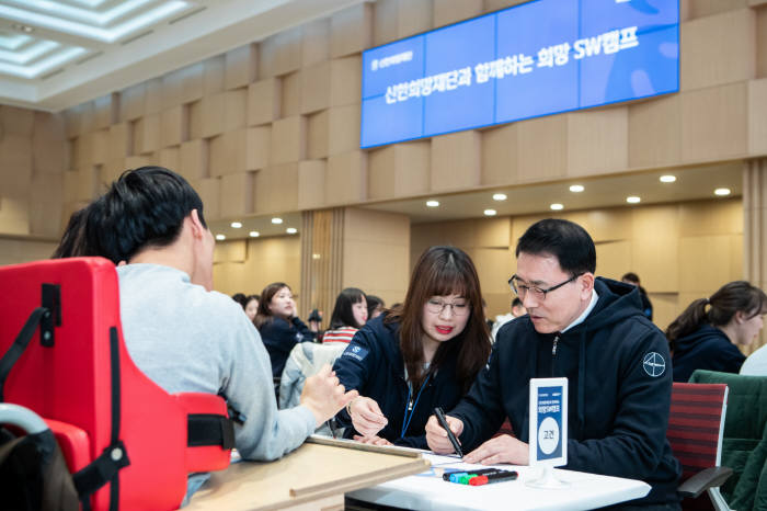 조용병 신한희망재단 이사장(사진 오른쪽)을 포함한 20여명의 신한금융그룹 직원들이 보조강사로 캠프에 참여해 학생과 함께 다양한 프로그램을 진행하고 있다.