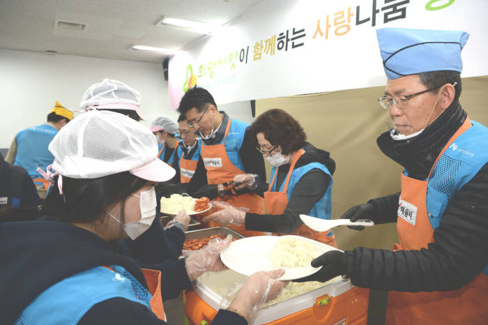 은성수 수출입은행장(오른쪽)이 29일 임직원들과 함께 서울역 인근 무료급식소 따스한 채움터을 찾아 노숙인에게 배식 봉사를 하고 있다.