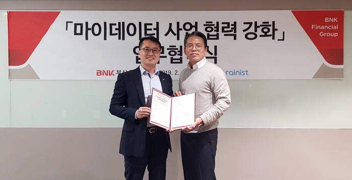 BNK부산은행이 지난 27일 고객 데이터를 활용한 맞춤형 금융서비스 제공을 위해 개인금융 관리서비스 전문기업 레이니스트와 마이데이터 사업 협력 강화 업무협약을 체결했다. 한정욱 BNK부산은행 디지털금융본부장(왼쪽부터)과 최재웅 레이니스트 최재웅 본부장이 기념촬영했다.