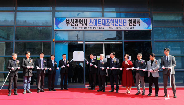 중소벤처기업부 김학도 차관은 부산 스마트제조 혁신센터 현판식을 하고 있다. 왼쪽부터 지에스티 김행곤 상무이사, 모아티티 한태진 대표,중소기업 기술정보진흥원 최철안 원장, 부산지방중소벤처기업청 조종래 청장,중기부 김학도 차관,부산시 일자리경제실 김윤일 실장, 부산테크노파크 최종열 원장,파나시아 이수태 대