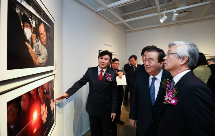 제55회 한국보도사진전 평화, 다시 하나로 개막식이 6일 서울 세종문화회관 미술관에서 열렸다. 이동희 한국사진기자협회장(맨 왼쪽)이 문희상 국회의장(왼쪽 두 번째), 이병규 한국신문협회장에게 전시된 사진을 설명하고 있다.