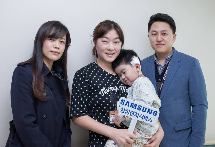 삼성전자서비스의 후원으로 인공달팽이관 수술을 받은 아동과 어머니(사진 가운데), 사랑의달팽이 재단 관계자(왼쪽)와 오지상 삼성전자서비스 한마음협의회 대표위원이 기념촬영했다.