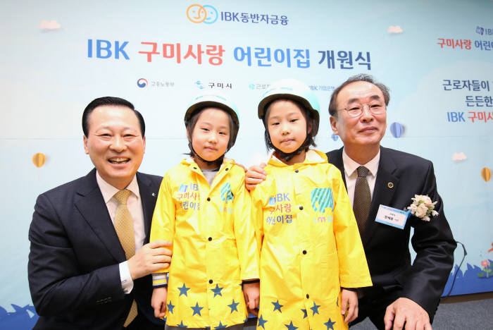 26일 구미에서 열린 IBK 구미사랑 어린이집 개원식에서 김도진 기업은행장(맨 왼쪽)과 장세용 구미시장(맨 오른쪽)이 박시은(오른쪽 두 번째), 박수현(왼쪽 두 번째) 어린이에게 선물을 전달하고 기념촬영했다.