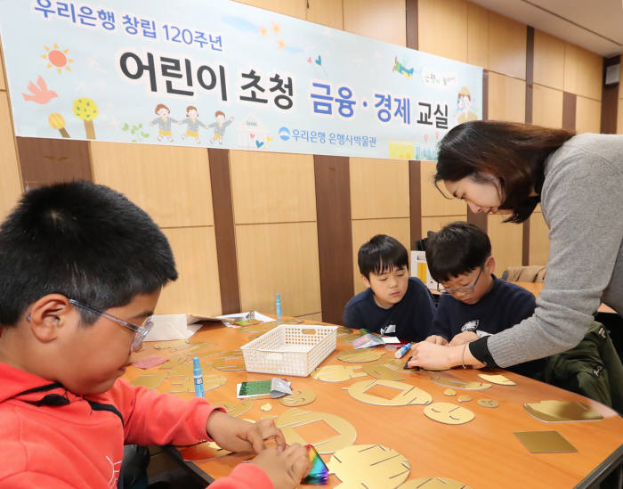 우리금융그룹은 지난달 30일 서울시 중구에 소재한 우리은행 박물관에서 유치원생, 초등학생들을 대상으로 어린이 금융 경제교실을 개최했다. 어린이들이 황금돼지 저금통을 직접 만들고 있다.