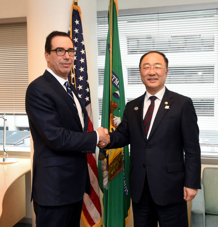 홍남기 경제부총리 겸 기획재정부 장관(오른쪽)이 스티븐 므누신 미국 재무장관과 악수하고 있다.