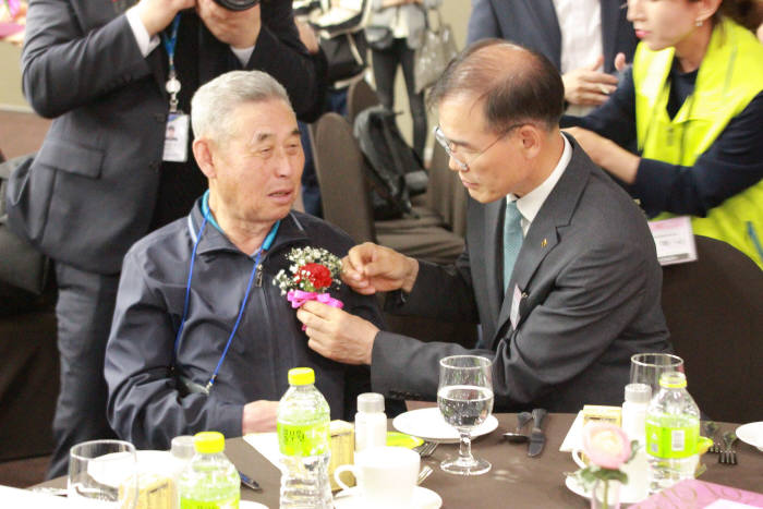 남영수 농협은행 부행장(오른쪽)이 행사에 참석한 어르신께 카네이션을 달아드리고 있다.