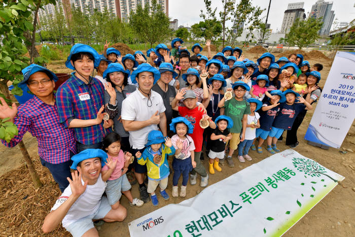 현대모비스 직원 가족 봉사단이 한강공원 이촌지구에서 현대모비스 정원을 조성하기 위해 팽나무와 갈참나무 묘목 100여 주를 심고 있다. 이들은 1년간 나무와 꽃을 심고 계절에 맞는 관리 활동을 한다. (제공=현대모비스)