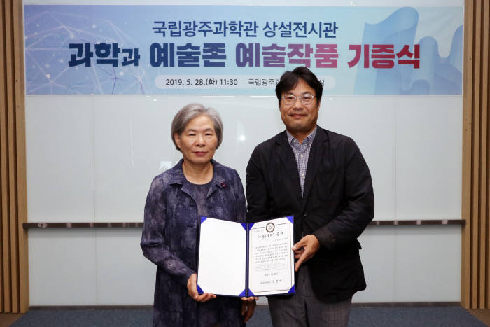 김선아 국립광주과학관장(왼쪽)이 28일 김병욱 조선대 디자인공학과 교수와 과학과 예술존 작품 기증식을 갖고 있다.