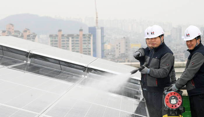 서울 관악구 KT 구로지사에서 관계자들이 태양광 패널에 쌓인 미세먼지를 물로 씻어 내고 있다. 이동근기자 foto@etnews.com