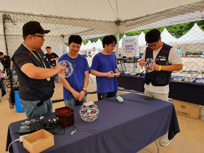 한국정보과학진흥협회 회원사 안산플라이존 부스에서 관람객이 드론 축구경기와 5G기술 접목 드론영상 체험 행사에 참여하고 있다.