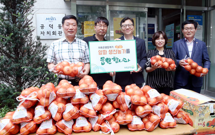 하은수 저축은행중앙회 전무(가운데)를 비롯해 관계자들이 24일 공덕동주민센터에서 양파 기탁 행사 후 기념촬영했다.