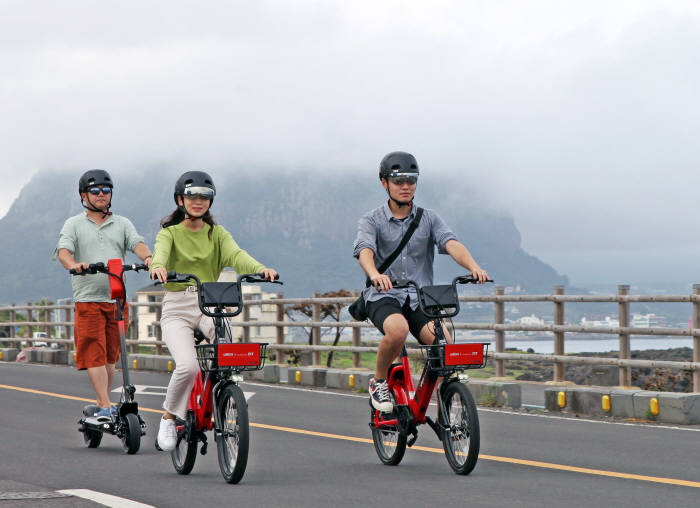 ZET 고객이 제주도 송악산 지역에서 공유형 전동킥보드와 전기자전거를 즐기고 있다.