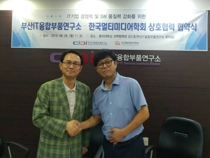 정석찬 부산IT융합부품연구소장(오른쪽)과 김치용 한국멀티미디어학회장이 MOU 체결 후 협력을 다짐하며 악수하고 있다.