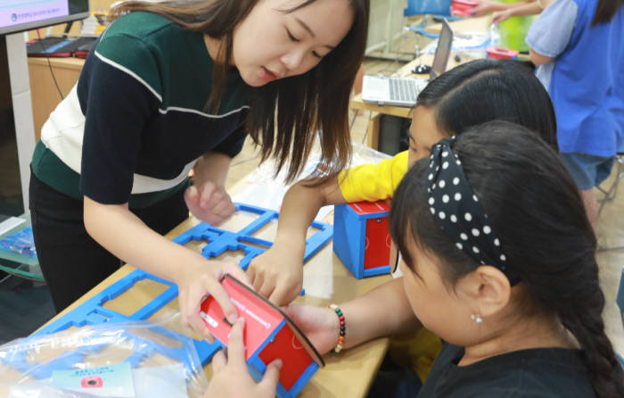 지난 26일 LG이노텍이 시립마포청소년센터에서 방과 후 아카데미 학생들을 대상으로 과학체험 교실을 개최했다. 행사에 참가한 학생들이 LG이노텍 직원과 체험키트를 활용해 블루투스 스피커의 원리를 실험하고 있다. (사진=LG이노텍)