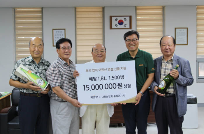 국순당 최영환 생산본부장(왼쪽 4번째)이 대한노인회 횡성군지회 전병수 지회장(왼쪽 3번째)에게 어르신께 전달할 차례주 예담을 28일 기증했다.