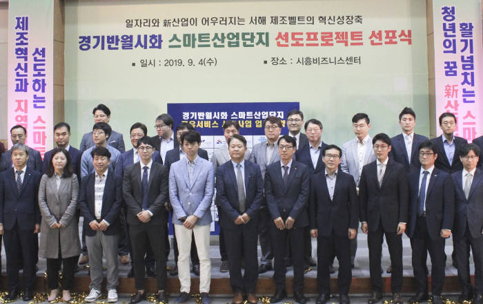 4일 시흥 비즈니스센터에서 열린 스마트산단 비전 선포식에서 SK인포섹이 한국산업단지공단과 공유 서비스 업무 협약을 체결했다. 이수영 SK인포섹 DS사업 그룹장(맨 앞줄 오른쪽 다섯번째)이 공유 서비스 참여 기업 관계자들과 기념촬영했다.