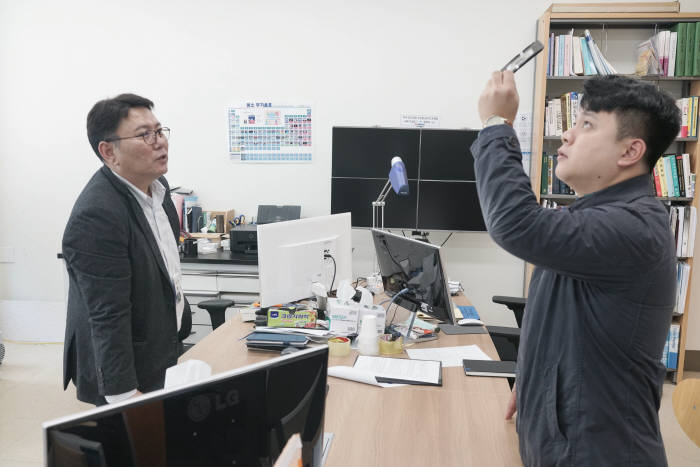 김도형 전력신소재연구실 책임연구원(왼쪽)과 본지 기자가 반투명 페로브스카이트 태양전지를 살펴보고 있다.