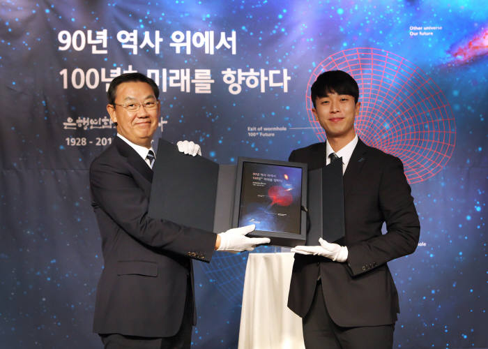 지난 1일 은행회관 국제회의실에서 열린 은행연합회 90년사 발간 기념식에서 김태영 은행연합회 회장(왼쪽)과 1990년생 직원 이승준 대리가 책자를 들고 기념촬영했다.