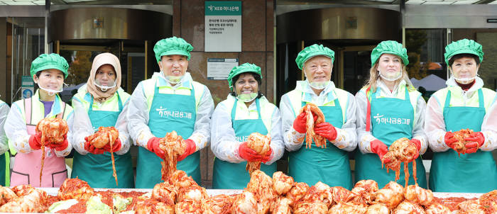 함영주 하나금융그룹 부회장(왼쪽 세번째), 박승 하나금융그룹 사회공헌위원장(왼쪽 다섯번째), 손병옥 하나금융그룹 사회공헌 부위원장(왼쪽 일곱번째), 다문화 이주 여성, 가족사랑봉사단원들이 소외계층에게 전달한 사랑의 김장을 담그고 있다.