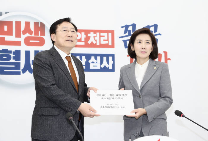 김기문 중소기업중앙회장이 14일 국회를 방문해 나경원 자유한국당 원내대표에게 근로시간 환경 규제 개선 중소기업계 건의서를 전달하고 있다.