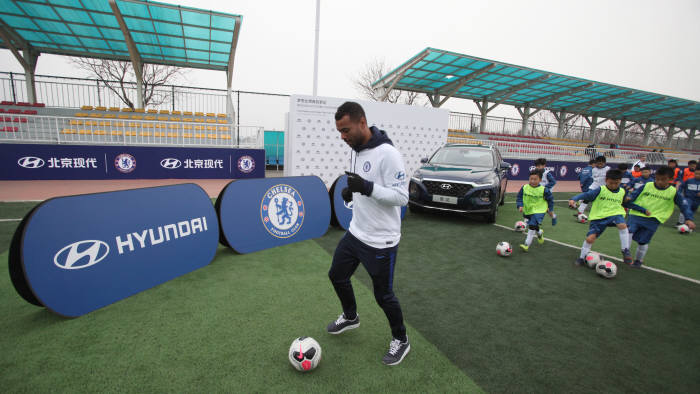 첼시 FC 레전드 애슐리 콜(Ashley Cole) 선수가 축구 캠프에 참가한 아이들과 함께 훈련을 하고 있는 모습.