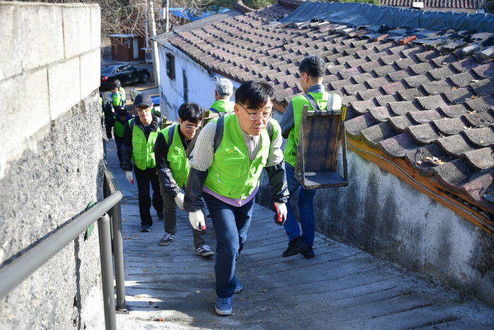 NH농협 IT사랑봉사단원들이 27일 성북구 정릉3동에서 연탄을 배달하고 있다.