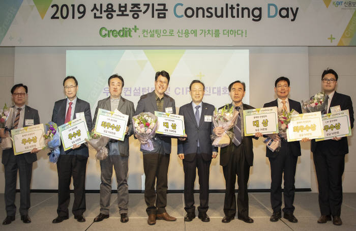 윤대희 신용보증기금 이사장이(오른쪽 네 번째)이 지난 9일 서울 마포구 가든호텔에서 개최된 2019 신용보증기금 컨설팅 데이에서 수상자들과 기념촬영을 하고 있다.