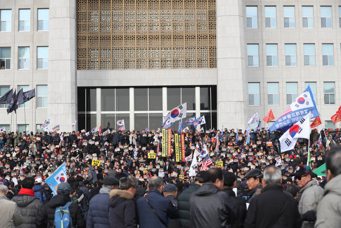 16일 오전 서울 여의도 국회에서 열린 공수처법 선거법 날치기 저지 규탄대회 참가자들이 본청 입구에서 시위를 벌이고 있다.