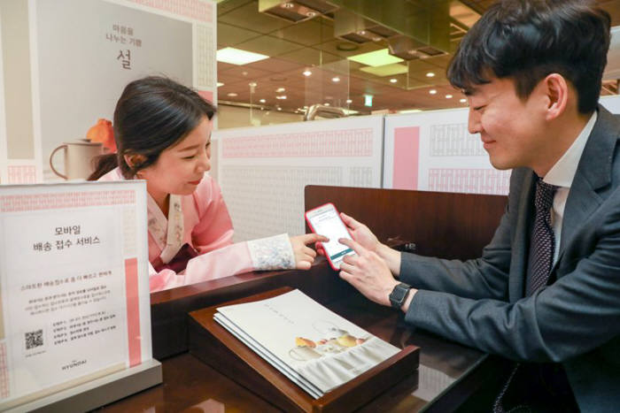 서울 강남구 현대백화점 압구정본점 지하 1층에 있는 명절 선물세트 접수 데스크에서 고객이 모바일 배송 접수 서비스를 이용하고 있다.