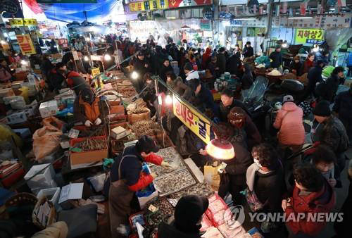 설 명절을 맞아 전통시장에서 물품을 구입하고 있는 사람들.[사진=연합뉴스]