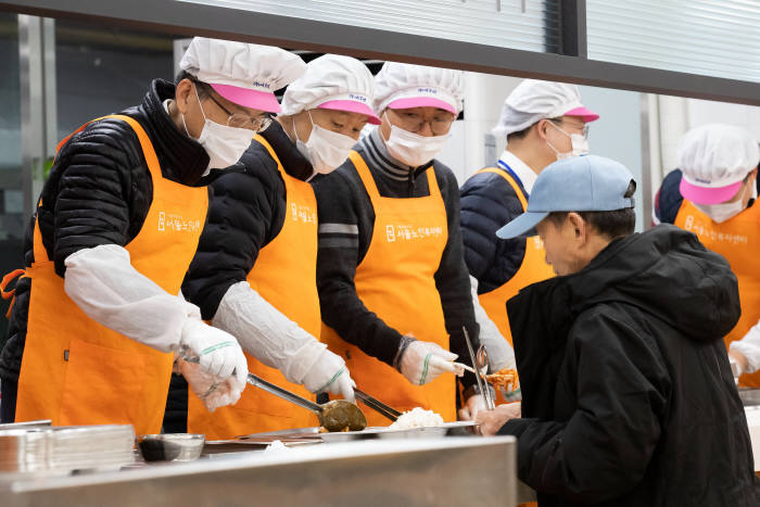 은성수 금융위원장(왼쪽부터), 이계문 서민금융진흥원장 등 자원봉사자들이 식사를 배식하고 있다.