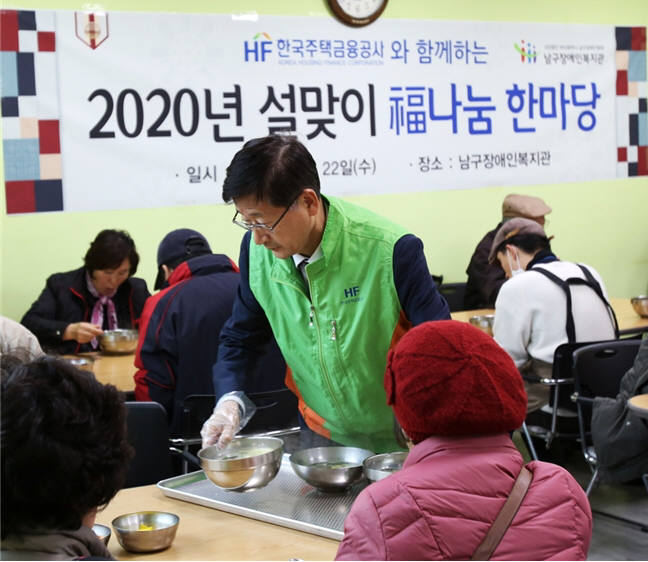 이정환 주택금융공사 사장이 복지관 이용자에게 떡국을 대접하고 있다.