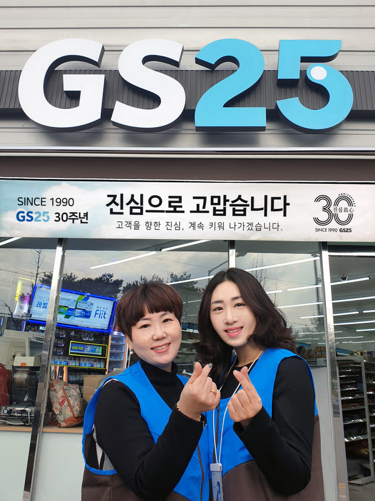 박윤정 GS25 호림공단점 경영주와 본부 영업담당 직원이 매장 앞에서 손으로 하트를 그려보이고 있다.