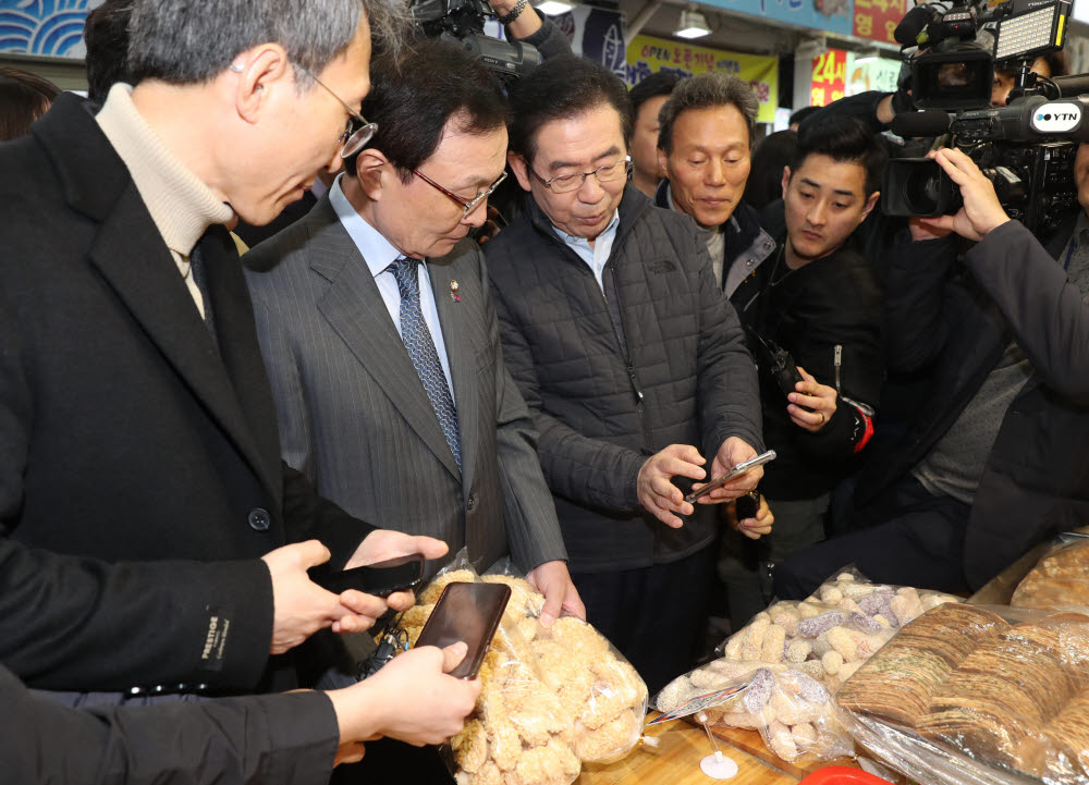 서울 시내 전통시장에서 박원순 서울시장(오른쪽)이 이해찬 더불어민주당 대표에게 제로페이 결제 시연을 보이고 있다. 이동근기자 foto@etnews.com