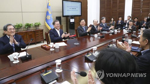 문재인 대통령이 10일 오후 청와대에서 열린 수석·보좌관회의에서 영화 기생충의 아카데미상 수상을 축하하며 참석자와 함께 박수치고 있다. 연합뉴스