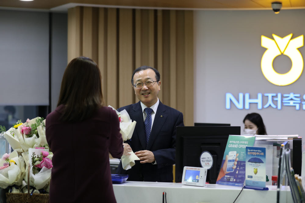 서울 강남구 소재 NH저축은행 본점영업부에서 실시한 꽃 나눔 행사에서 김건영 대표(가운데)가 영업점 내방고객에게 꽃을 나눠주고 있다.