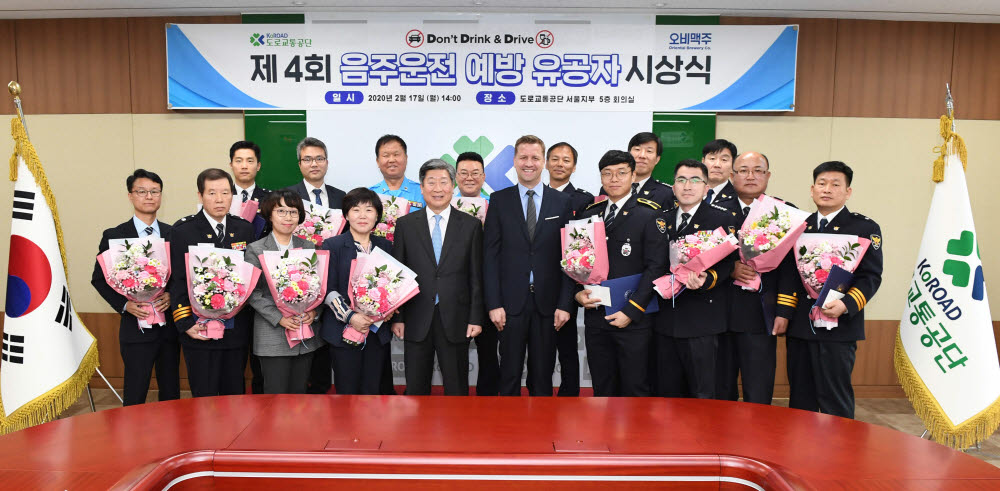 도로교통공단 서울지부에서 오비맥주 배하준 대표(첫째 줄 오른쪽 다섯번 째)와 도로교통공단 윤종기 이사장(첫째 줄 오른쪽 여섯번 째)이 음주운전 예방 유공자들과 시상식을 마치고 기념촬영을 하고 있다.