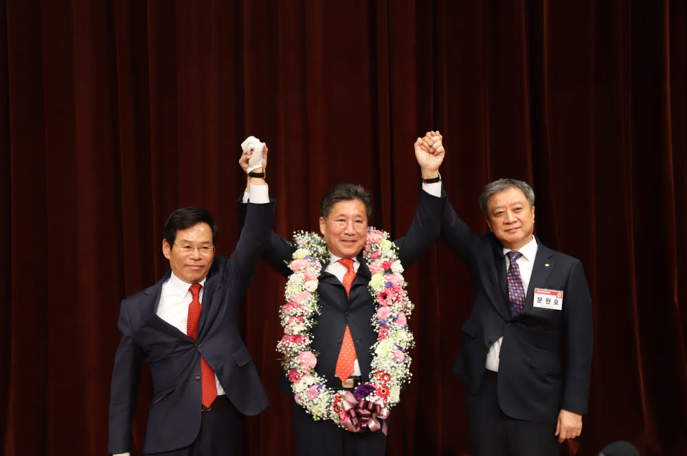 류재선 한국전기공사협회 회장(가운데)이 제26대 회장 연임에 성공한 후 김성관 전기공사공제조합 이사장(왼쪽), 문원호 중앙선거관리위원장 손을 번쩍 들어올리고 있다.