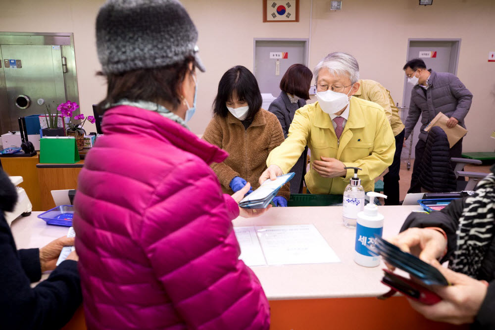 최기영 과학기술정보통신부 장관(오른쪽)이 세종장군우체국을 찾은 시민에 마스크를 전달하고 있다.