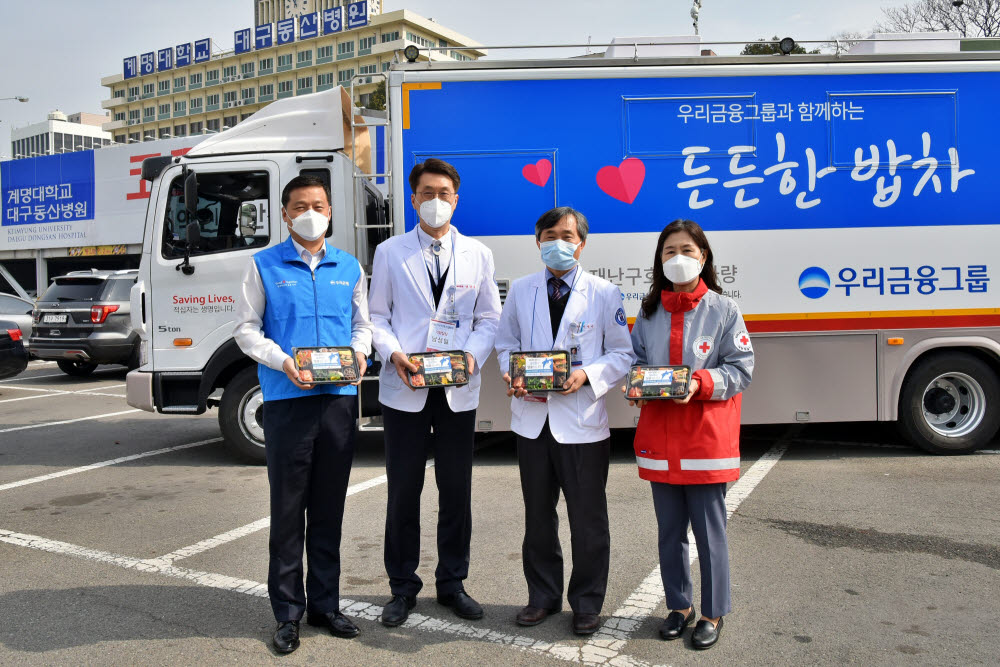 우리금융그룹은 코로나19의 급속한 확산으로 최일선에서 사투를 벌이고 있는 대구 지역거점병원 의료진을 위해 지난 9일부터 든든한 도시락 지원사업을 실시하고 있다. 우리금융그룹은 코로나19 사태가 진정될 때까지 심신 회복과 면역력 강화에 도움을 주는 든든한 도시락을 매일 점심 제공할 계획이다. 서영성(왼쪽 세번째) 대구동산병원 병원장, 박선영(왼쪽 네번째) 대한적십자사 대구지사 사무처장 등