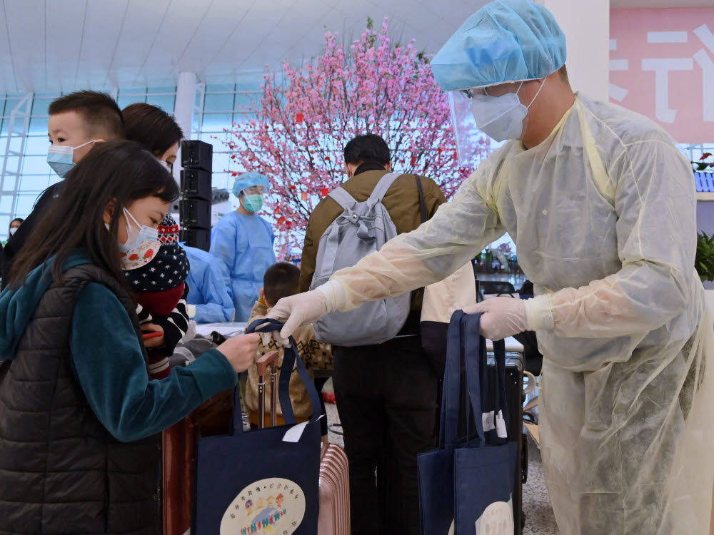 epa08325662 A handout photo made available by Hong Kongs Information Services Department (ISD) shows a Hong Kong Immigration Department staff member wearing protective gear and distributing gift packs to Hong Kong residents at the Wuhan Tianhe International Airport, in Wuhan, China, 26 March 2020 (issued 27 March 2020). Over 500 stranded Hong Kong residents have been flown back on four government chartered flights from Hubei province, China, this week. EPA/ISD HANDOUT INFORMATION SERVICES DEPARTMENT/ HANDOUT / EDITORIAL USE ONLY/NO SALES HANDOUT EDITORIAL USE ONLY/NO SALES