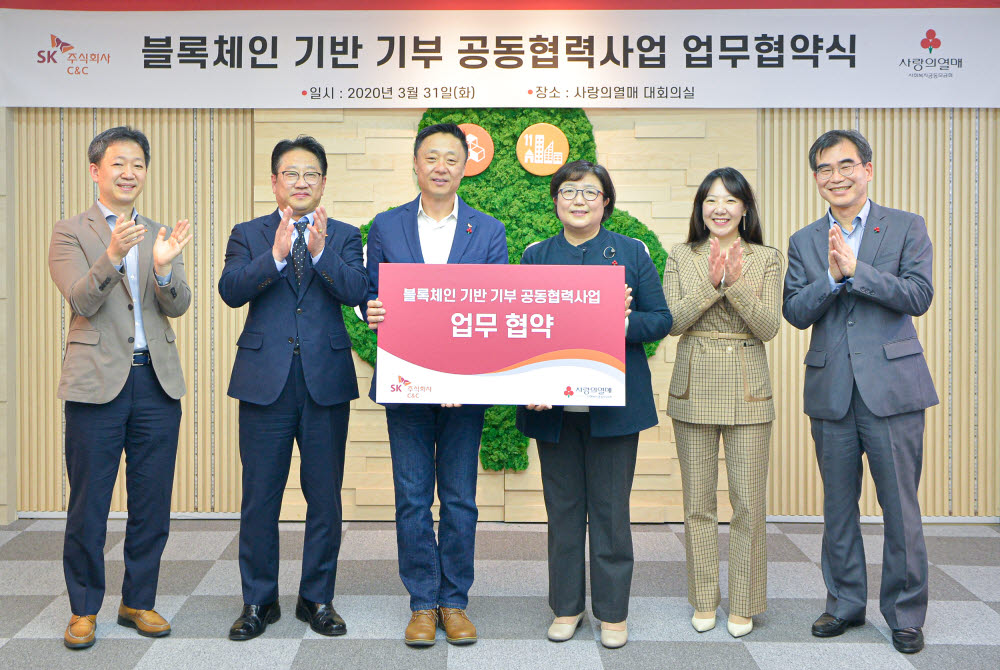 31일 사랑의열매회관에서 김연순 사랑의열매 사무총장(왼쪽에서 네 번째)과 김영대 SK(주) C&C 디지털테크 센터장(왼쪽에서 세 번째)을 비롯해 양사 관계자가 블록체인 기반 기부 플랫폼 공동협력 사업 협약 체결 후 기념촬영하고 있다. SK(주)C&C 제공